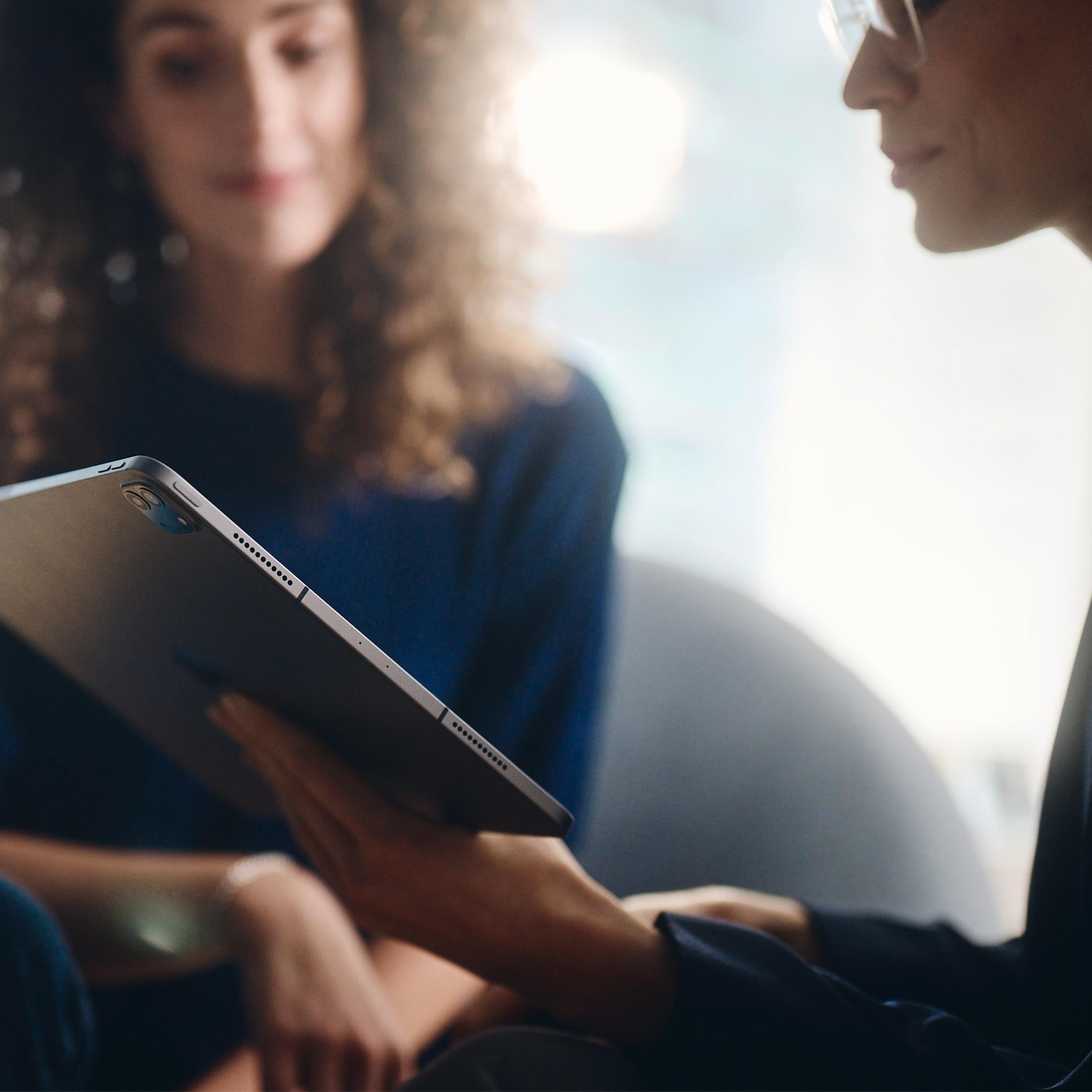 Două femei care se uită la o tabletă.