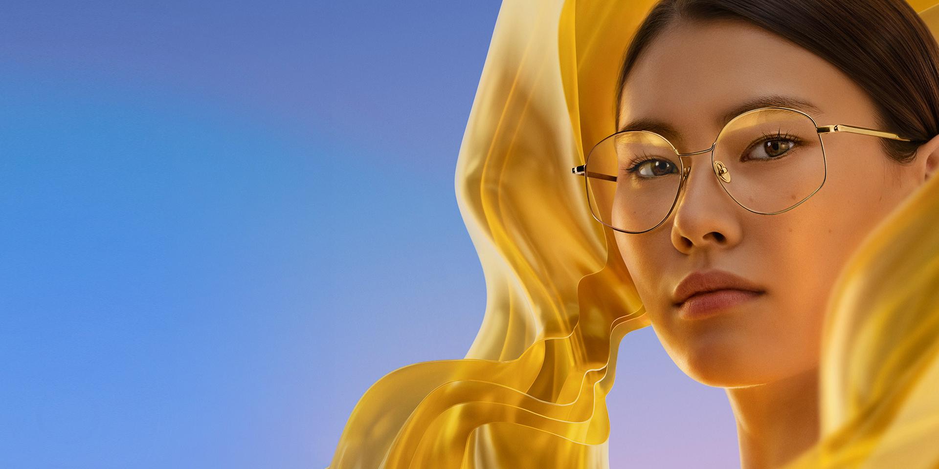 O femeie care poartă ochelari de vedere incolori cu ZEISS DuraVision Gold UV, adăugând o reflexie aurie subtilă dar distinctivă lentilelor.
