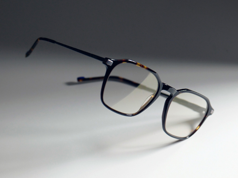 O imagine cu lentile de ochelari incolore într-o ramă maro, cu o nuanță subtilă aurie ZEISS DuraVision Gold UV.