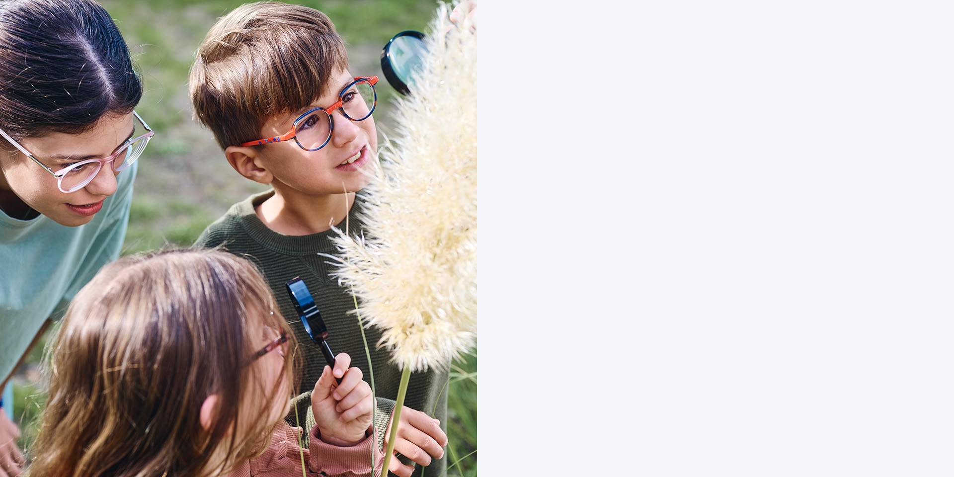 2 fete și 1 băiat care poartă lentile ZEISS MyoCare. Ei se uită la o plantă, doi dintre cei trei copii se uită la plantă prin lupă.
