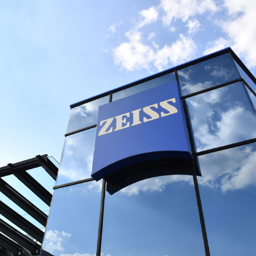 O imagine cu o clădire de sticlă modernă cu sigla ZEISS. 