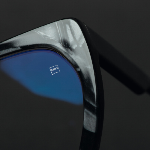 O imagine de aproape a unei lentile de ochelari într-un cadru negru cu logoul ZEISS vizibil. 