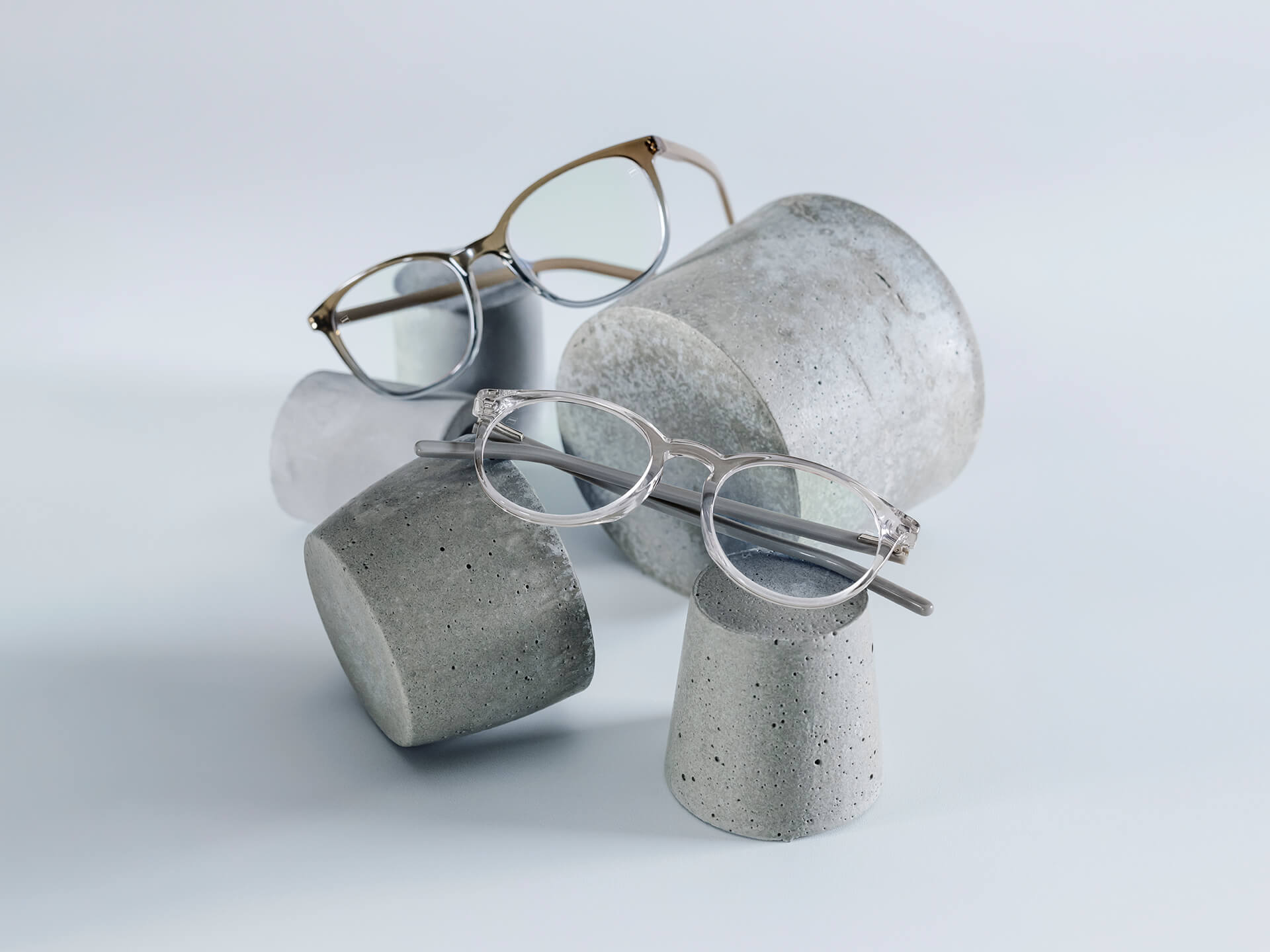 Ochelarii cu lentile ZEISS care au tratament DuraVision® Chrome sunt așezați pe piedestale din piatră de diferite dimensiuni.