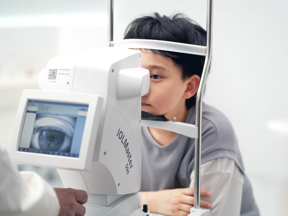 Ochii unui băiețel sunt examinați cu un ZEISS IOLMaster.