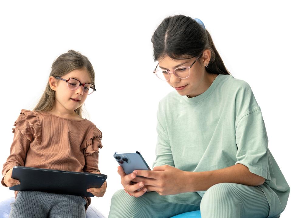 Două fete care se uită la dispozitive digitale la o distanță sugerată de peste 20 cm.
