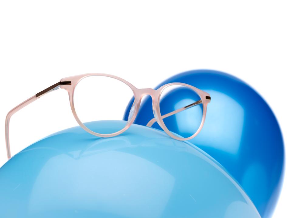 Ramă roz pentru ochelari cu lentile ZEISS MyoCare pe un balon albastru.