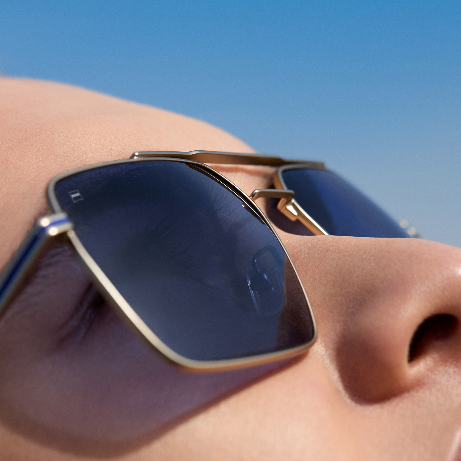 Un prim-plan cu un bărcat care poartă ochelari de soare ZEISS cu rețetă în nuanță Midnight Blue. 