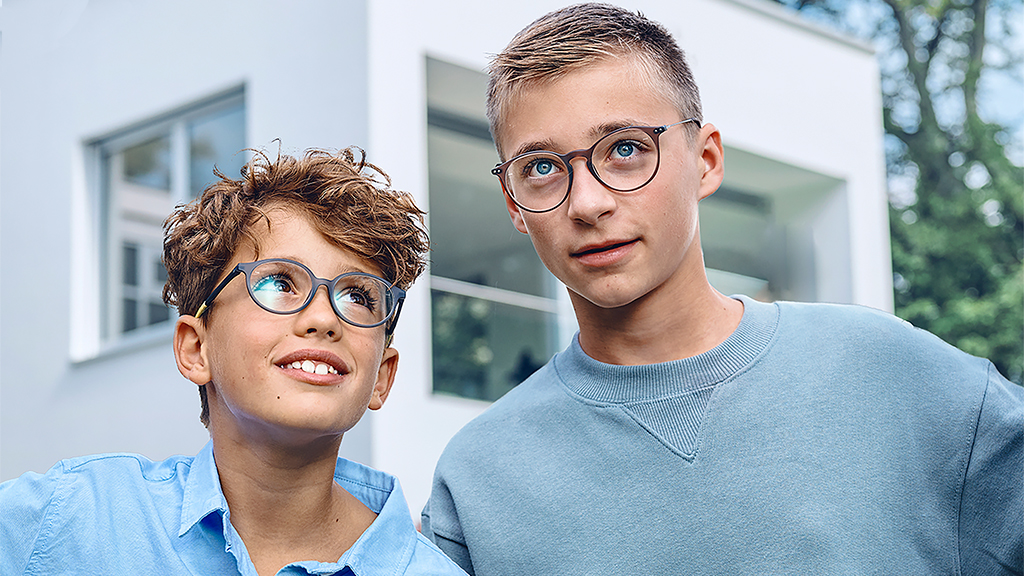 Un tânăr care se uită la un adolescent, ambii purtând ochelari cu lentile monofocale ZEISS SmartLife Young